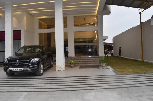 a black car parked in front of a building at Hotel VPS Grand in Palani