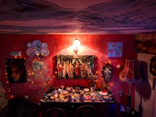 Room in Lodge - Romantic getaway to Cuenca at Christmas في Valeria: غرفة بجدار احمر مع طاولة مليئة بالعناصر