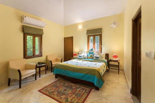 a bedroom with a bed and a table and chairs at Pench Jungle Camp in Khawāsa