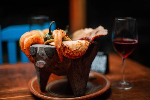 a bowl of shrimp on a table next to a glass of wine at Hotel & Suites Cerro Roj0 in Tlatlauquitepec