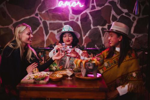 a group of three women sitting at a table with drinks at Hotel & Suites Cerro Roj0 in Tlatlauquitepec