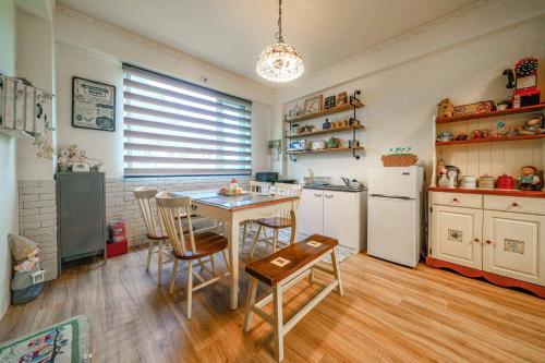 a kitchen with a table and chairs and a refrigerator at 宜蘭敲敲門民宿2-6人包棟-每次只接待一組客人 in Shangwu