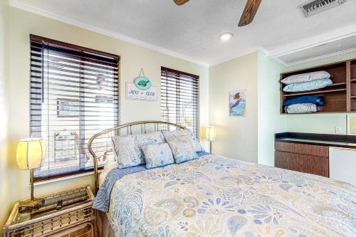 a bedroom with a bed and a kitchen with windows at Pelican House in Saint Joe Beach