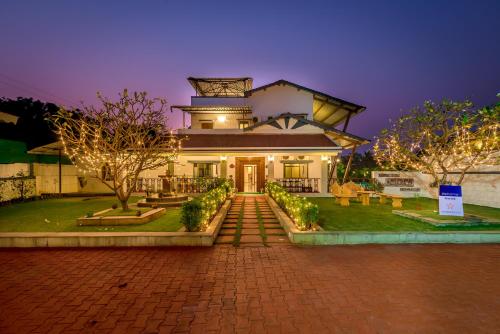 a building with a tower on top of it at SaffronStays Adora Woods & Hills, Luxury Pool Villa in Murud in Jambrung 