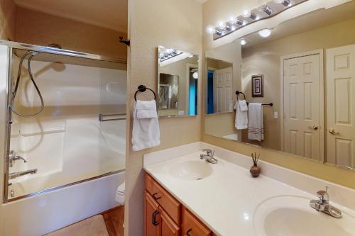 a bathroom with a sink and a shower and a mirror at Settlers Run Escape in Flagstaff