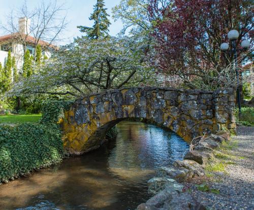 un pont en pierre sur une rivière dans un parc dans l'établissement Columbia Gorge Hotel & Spa, à Hood River