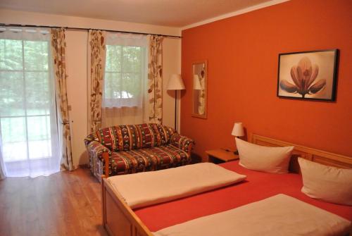 ein Wohnzimmer mit einem Sofa und einem Stuhl in der Unterkunft Zwieseler Waldhaus in Lindberg