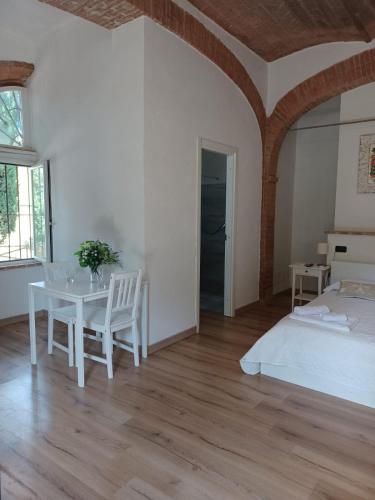 a bedroom with a bed and a table and chairs at L'Albero Di Gamelì in Chiusi