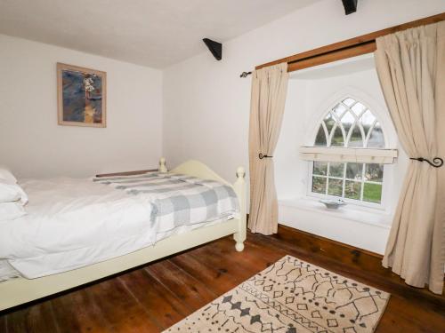 een slaapkamer met een bed en een raam bij Destiny Cottage in Boscastle