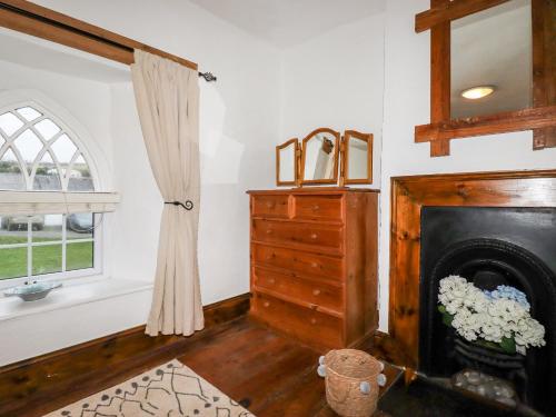 een woonkamer met een open haard en een raam bij Destiny Cottage in Boscastle