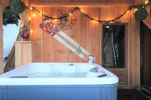 eine Whirlpool-Badewanne in einer Hütte mit Weihnachtsbeleuchtung in der Unterkunft Chalet Miravidi, Montchavin-La Plagne, Jacuzzi & Sauna in Montchavin