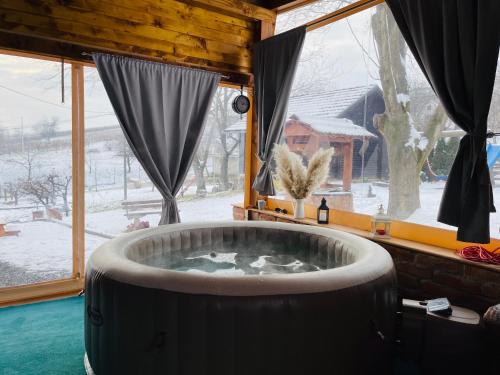 Holiday home DEDINA HIŽICA في Sveti Urban: حوض استحمام ساخن في غرفة مع نافذة