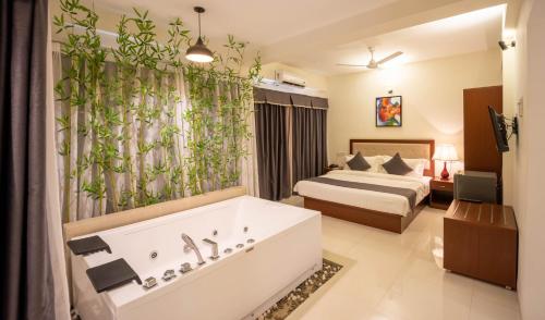 a hotel room with a bed and a bath tub at Hotel Reemz Beach Heaven , Anjuna in Anjuna