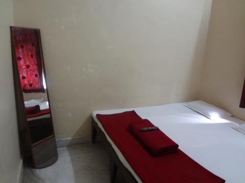 a bedroom with a bed with a red towel on it at Hotel Rajmandir in Pune
