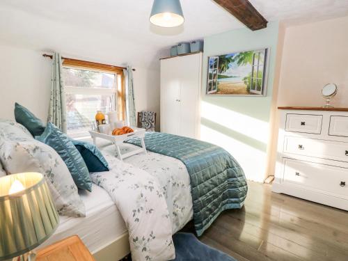 a bedroom with a bed and a window at Palm Tree Cottage in Great Yarmouth
