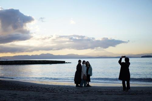 a group of people standing on the beach at The Bath & Bed Hayama in Hayama