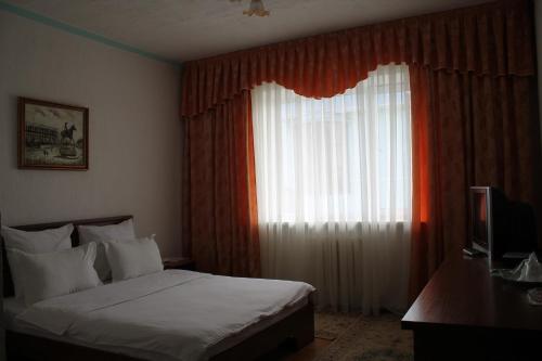 a hotel room with a bed and a window at Green Hotel in Almaty