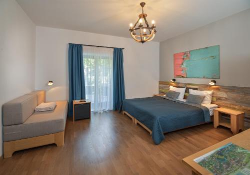 a bedroom with a bed and a couch and a chair at Butikhotel Visegrád in Visegrád