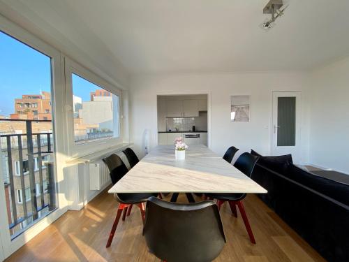 a dining room with a table and chairs and a large window at Luxury 3 bedroom apartment on the top floor with panoramic view in Ostend