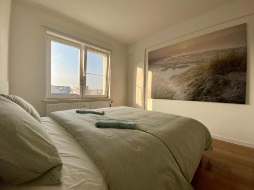 a bedroom with a bed with a painting on the wall at Luxury 3 bedroom apartment on the top floor with panoramic view in Ostend