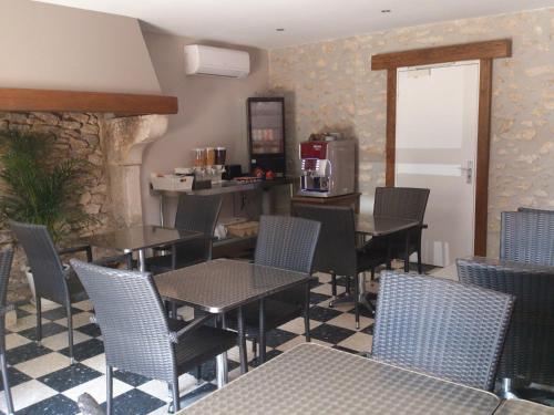 un restaurant avec des tables et des chaises et une cuisine dans l'établissement Hôtel Les Petits Oreillers, à Saint-Martin-dʼArdèche