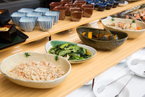 a display case with bowls of food on a table at Urban Hotel Kyoto Nijo Premium in Kyoto