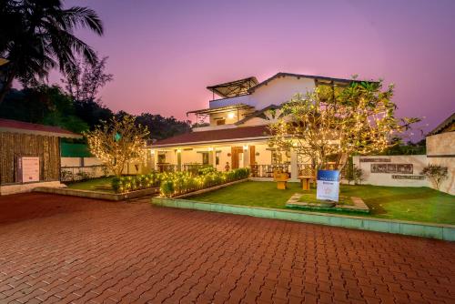 a house with a brick driveway in front of it at SaffronStays Adora Woods & Hills, Luxury Pool Villa in Murud in Jambrung 