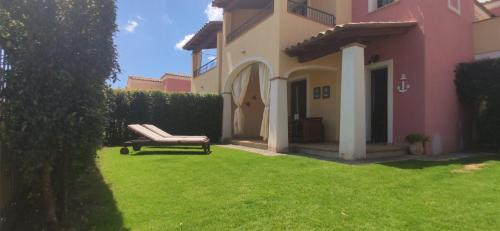 un banco en un patio junto a una casa en Casa di Lisa, en Villasimius