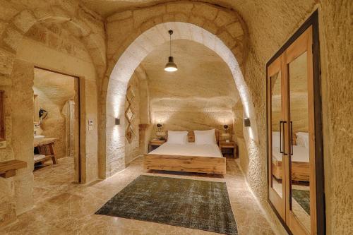 a bedroom with a bed in a stone walled room at Solem Cave Suites in Urgup