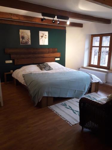 une chambre avec un grand lit dans une pièce dans l'établissement La Grande Ferme, à La Chapelle