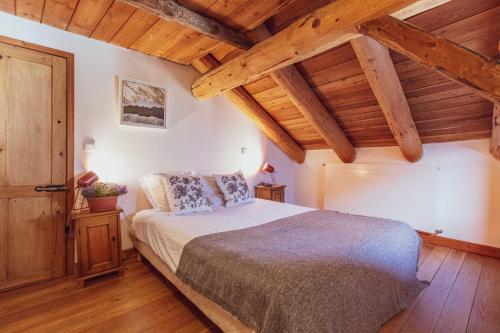 - une chambre avec un grand lit et des plafonds en bois dans l'établissement Maison Amalka, à Montgenèvre