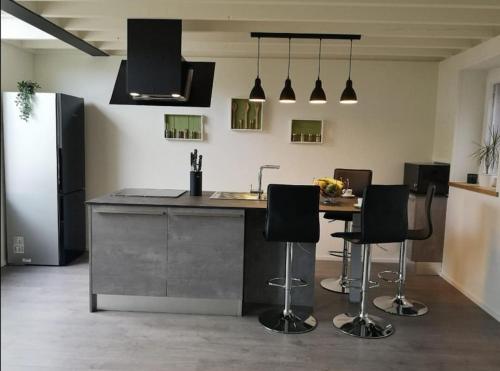 a kitchen with a island with bar stools in it at Ô'bel Écrin in Aubel