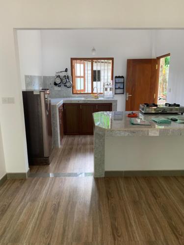 an empty kitchen with wooden floors and a counter top at Zentinal in Unawatuna
