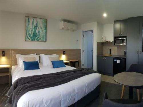 a bedroom with a large bed and a kitchen at Jervis Bay Motel in Huskisson