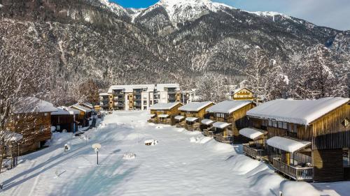 a village covered in snow with mountains in the background at Lake Resort Pressegger See in Hermagor