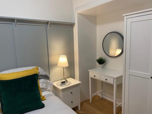 een kleine slaapkamer met een bed en een spiegel bij The Howff - Lovely 2-Bed Apartment in Anstruther in Anstruther