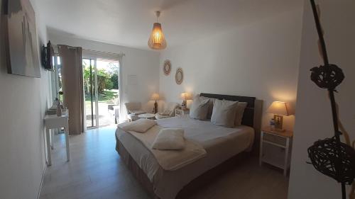1 dormitorio con 1 cama grande con sábanas y almohadas blancas en Chambres d'Hôtes du Hourne en Saint-Pandelon