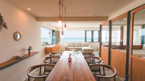 a living room with a wooden table and chairs at Blue Steak Wonder Nagahama in Yomitan