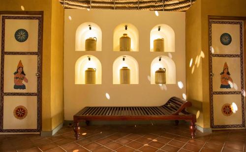 a bench in a room with arches on the wall at Aliya Resort and Spa - Thema Collection in Sigiriya
