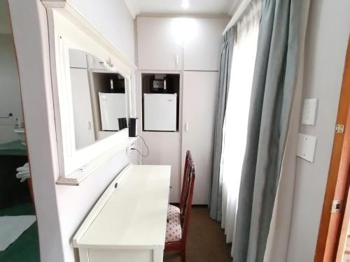 a bathroom with a white vanity and a mirror at Van Dykshuis Guest House in Heidelberg