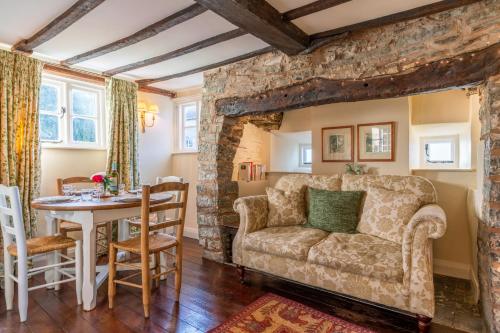 a living room with a couch and a table at Corner Cottage in Bretforton
