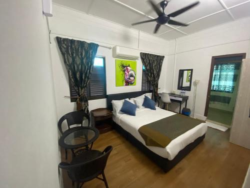 a bedroom with a bed and a ceiling fan at BoraBora Beach Guesthouse Penang in George Town