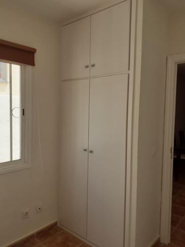 a white room with white cabinets and a window at Villa Rosa in Callao Salvaje