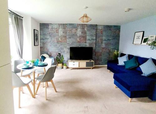 a living room with a blue couch and a table at Stylish 2 bedroom Apartment / FREE Gated Parking in Glasgow