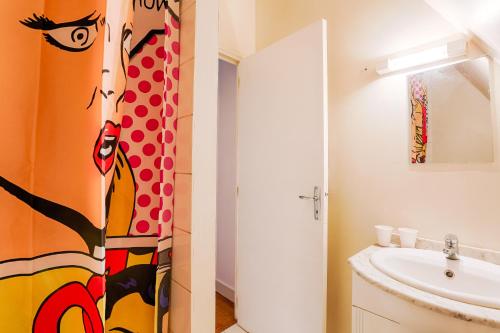 a bathroom with a painting of a woman on the wall at Calvaloft in Bons-Tassily