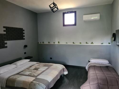 1 dormitorio con 2 camas y ventana en B&B Villa Hermes, en Sarno