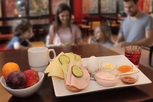 a plate with a sandwich and fruit on a table at Jugendherberge City-Hostel Köln-Riehl in Cologne