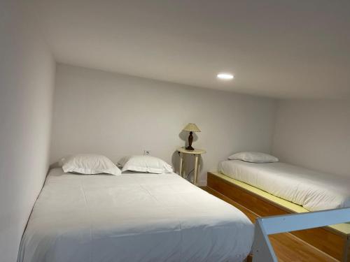 2 camas en una habitación con paredes blancas en Apartamentos Sol Mayor, en Madrid