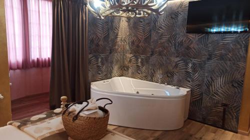 a bathroom with a bath tub and a wall at La Bocchetta Romantic Spa Hotel e Ristorante in Conco