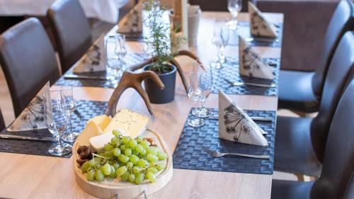 a table with a basket of grapes on it at Sunny Ferienwohnungen Ski In - Ski Out - Self Check-in in Zell am See